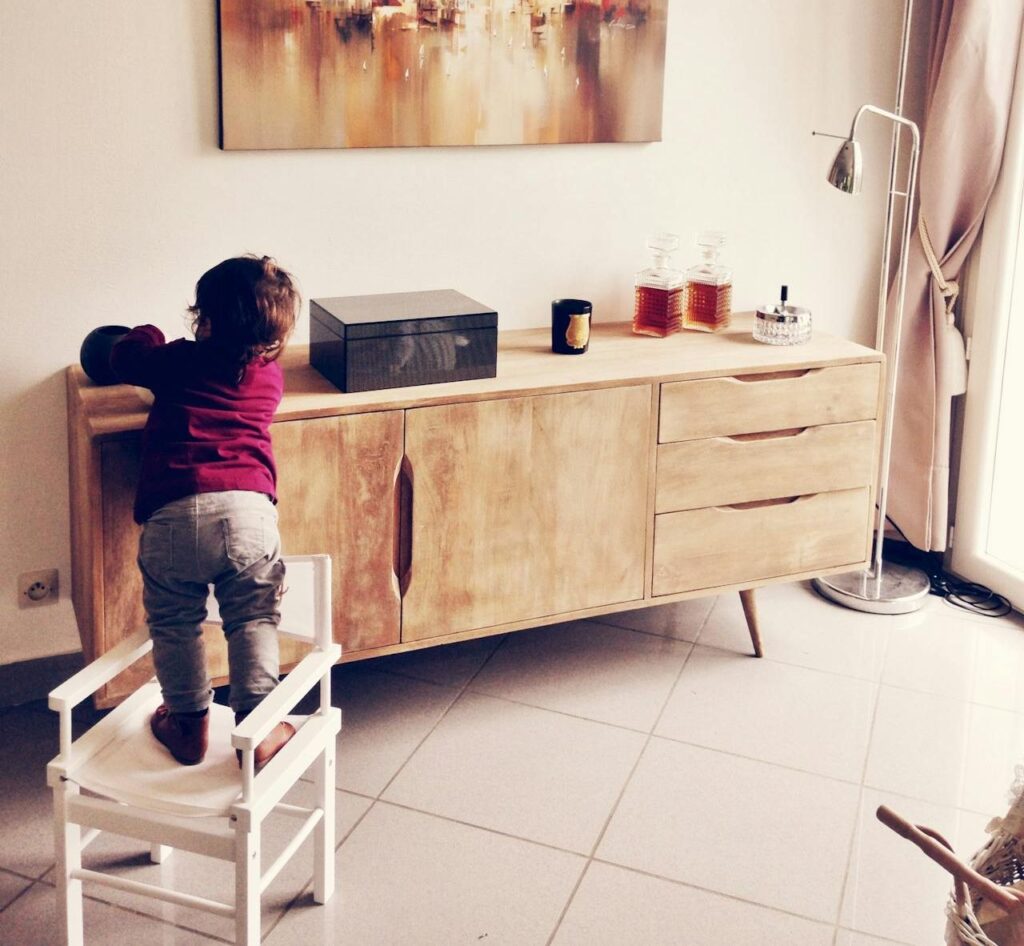 Criança brincando em cima de uma cadeira , risco eminente